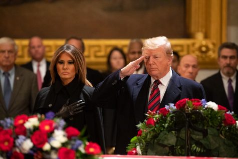 Photo Credit: Photo via Flicker Images under the creative commons license. President Donald J. Trump, joined by First Lady Melania Trump, salutes at the casket of former President George H. W. Bush.
