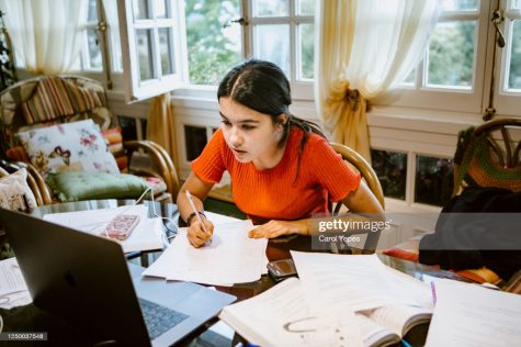  A student works on assignment in her room. All rights reserved under the creative commons license. Getty images.