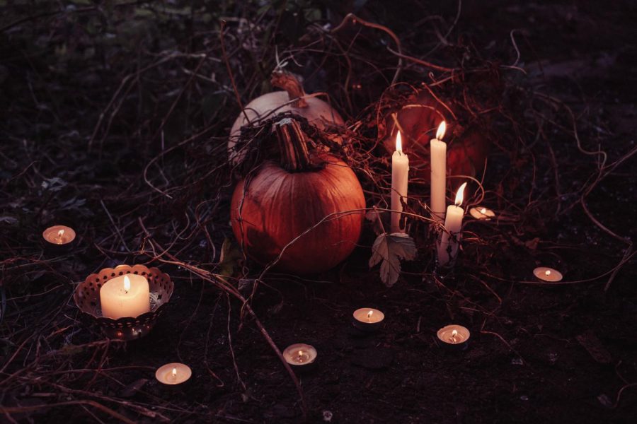 Pumpkins and candles in vines resemble the paranormal energy and eerie ambiance surrounding the fall season. Photo via Unsplash pictures under creative commons license.