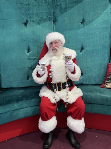 Santa kicking off the season, holding holiday drinks from Starbucks!