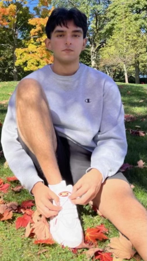 Muhammad Qasim is posing as he is sitting in the park.