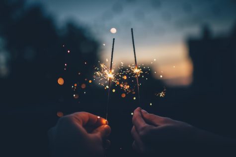 Person holding a firecracker to symbolize possibility in the New Year.