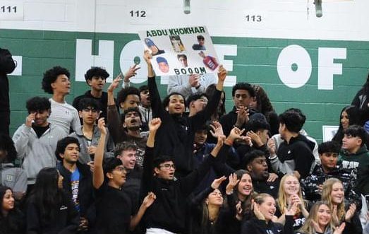 The student section erupts sending an electric feeling through the gym after Abdullah knocks down a big three during a basketball game.
