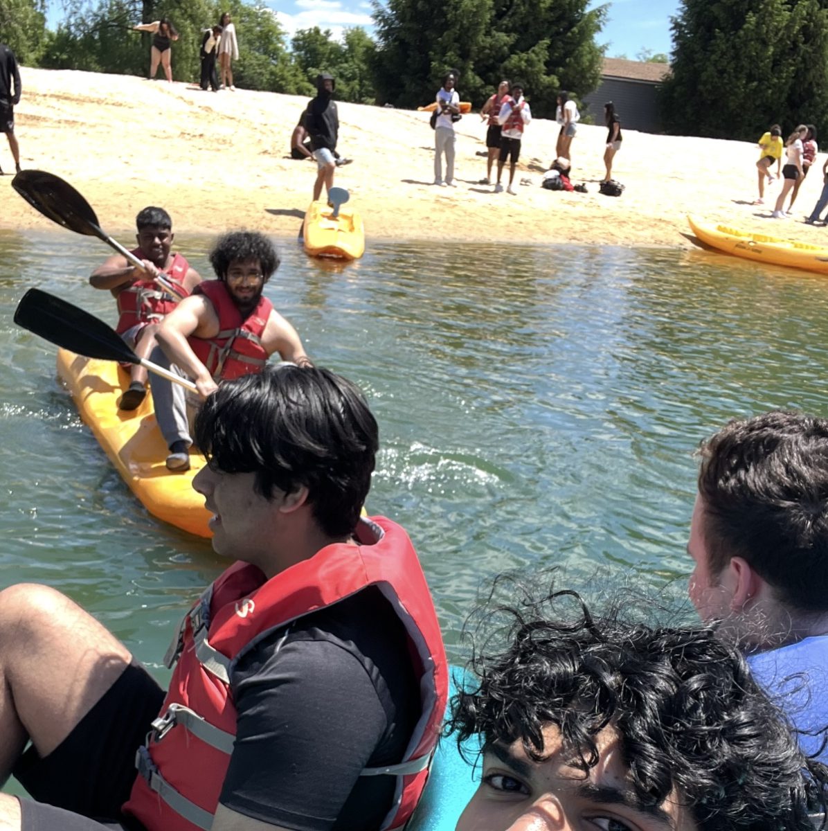 Seniors kayak and paddle boat along the shore at Frogbridge day camp. 